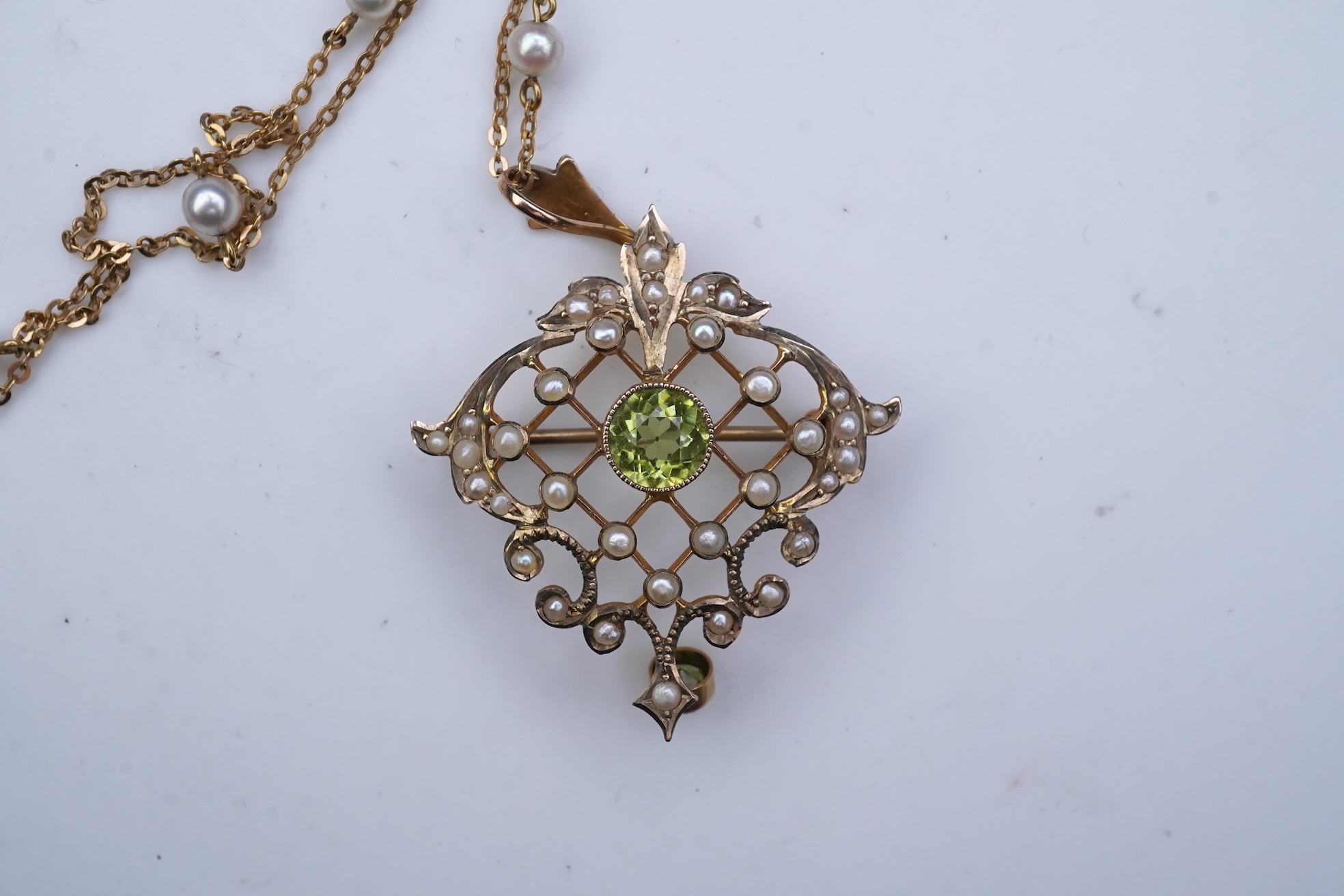 An Edwardian peridot and seed pearl pendant/brooch, early 20th century